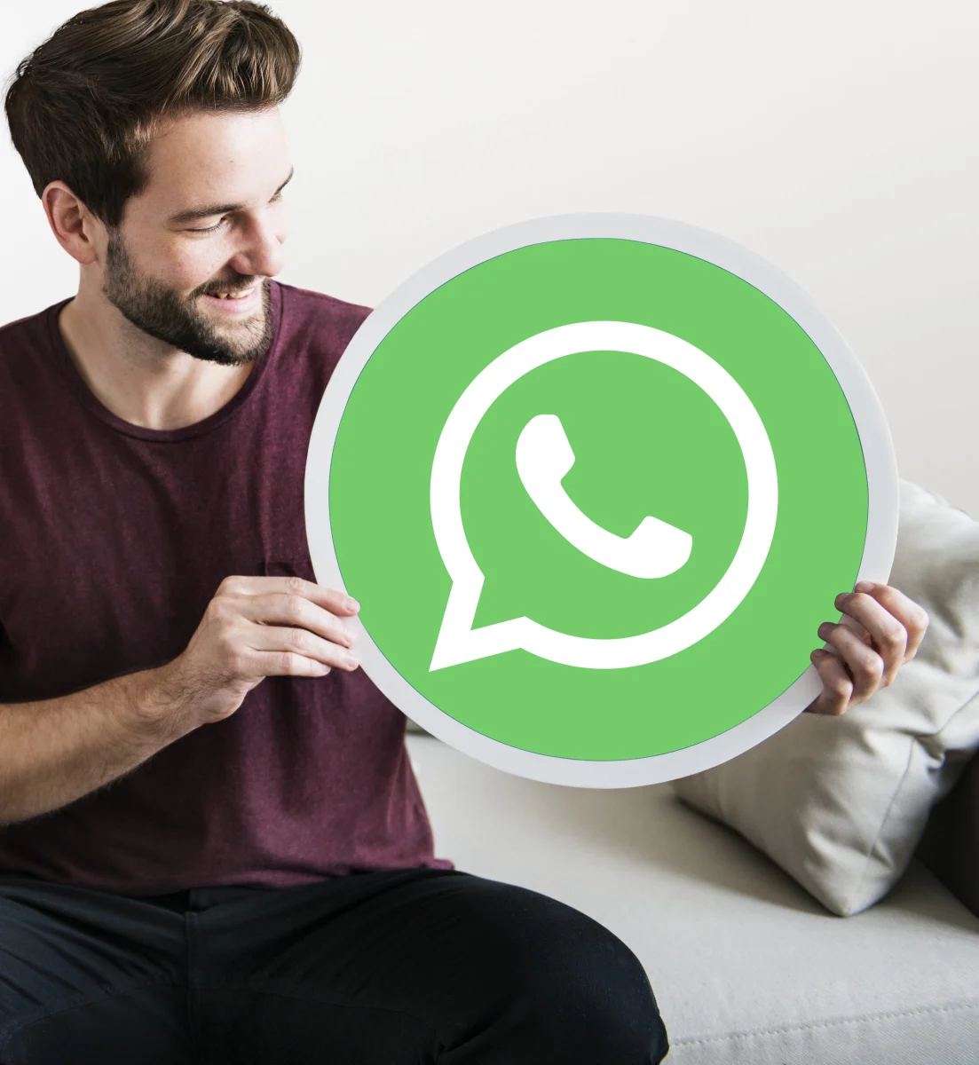 A person holding the WhatsApp logo
