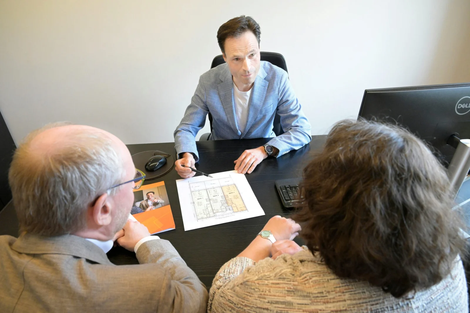 A manager briefing a colleague across a desk